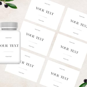 Peut inclure: Un flacon de complément alimentaire en plastique blanc avec un bouchon strié et une étiquette rectangulaire portant le texte YOUR TEXT en police serif, accompagné de cinq étiquettes en papier assorties, le tout avec des branches d'olivier.