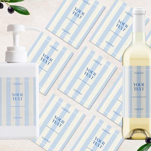 Op de afbeelding: Een witte pompflacon en een glazen wijnfles, beide voorzien van rechthoekige etiketten met lichtblauwe en witte verticale strepen. Elk etiket toont de tekst YOUR TEXT in het blauw, gecentreerd binnen een dunne blauwe rechthoekige rand.