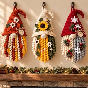 Peut inclure: Trois décorations murales en forme de gnome au crochet. Le gnome de gauche a un chapeau rouille avec des fleurs et une barbe aux couleurs d'automne avec une étiquette Hello Fall. Le gnome central a un chapeau crème avec un tournesol et une abeille, et une barbe jaune et verte avec une étiquette Bee Kind. Le gnome de droite a un chapeau rouge avec des flocons de neige et une barbe blanche et grise avec des pommes de pin et une étiquette Let it Snow.