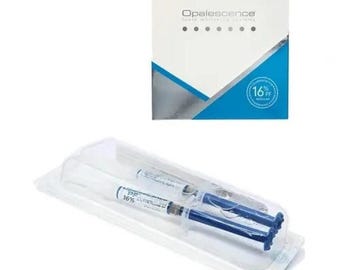Peut inclure: Une boîte blanche et bleue étiquetée Opalescence tooth whitening systems avec un graphique circulaire 16% PF regular. Sous la boîte se trouvent deux seringues en plastique transparent contenant du gel, scellées dans un emballage blister.
