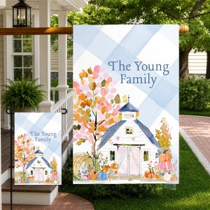 May include: A rectangular garden flag featuring a light blue and white buffalo check background. The design displays a white barn with a steeple, a colorful autumn tree, hay bales, and pumpkins. The text reads The Young Family in blue font.