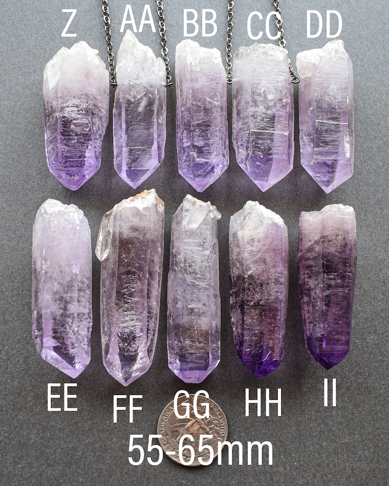 May include: Ten amethyst crystal points, each with a silver chain attached, are arranged in two rows of five. The crystals are approximately 55-65 mm in length. The crystals are a light purple color and have a clear, glassy appearance.