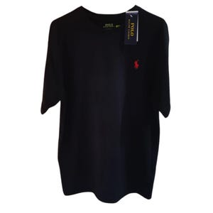 May include: A solid black short-sleeve t-shirt featuring a small red embroidered logo of a person on a horse on the left chest. The shirt includes a dark blue brand tag attached to the collar and a printed brand label on the inside neck area.