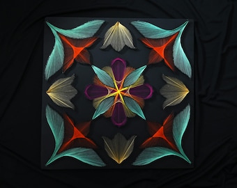 May include: A square string art piece on a black background featuring a central floral mandala pattern in purple, teal, and yellow. Four corner motifs display red and teal geometric shapes, while four side accents show gold thread designs.