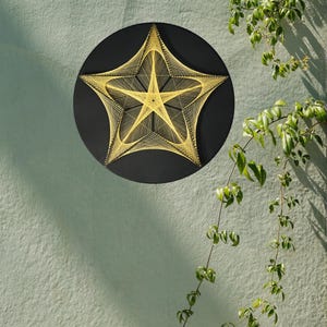 May include: A circular black wall art piece featuring a five-pointed star design created with yellow string art. The yellow threads are tightly wound around small nails to form geometric patterns, contrasting against the solid black background.