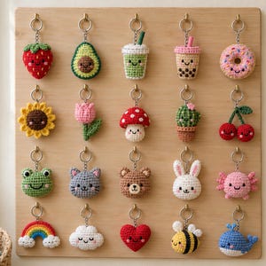 May include: A collection of twenty small, crocheted keychains featuring various designs including a strawberry, avocado, boba tea, donut, sunflower, tulip, mushroom, cactus, cherries, frog, cat, bear, rabbit, axolotl, rainbow, cloud, heart, bee, and whale.