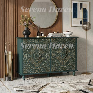 May include: A dark green sideboard cabinet featuring intricate gold-colored floral carvings on its two doors. The piece stands on four small feet and is topped with a black vase, a small tray with bottles, a stack of books, and a white bowl.