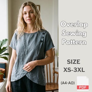Peut inclure: Un haut bleu ardoise à manches courtes avec un panneau avant superposé fixé par trois boutons sombres à l'épaule. Le texte indique Overlap Sewing Pattern, SIZE XS-3XL, (A4-A0) et PDF. Le vêtement présente une encolure et un ourlet arrondis.