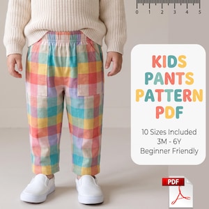 Peut inclure: Patron PDF de pantalon pour enfants avec un motif à carreaux multicolore dans des tons jaune, rose, bleu et orange. Le texte indique KIDS PANTS PATTERN PDF, 10 Sizes Included 3M - 6Y, Beginner Friendly. Une règle en haut affiche des mesures.