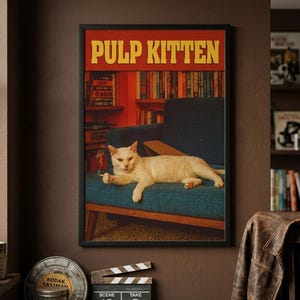 May include: A framed rectangular poster titled PULP KITTEN in yellow block letters. The image features a white cat lying on a blue sofa in a room with bookshelves. The cat holds a small white object in its paw, mimicking a cinematic scene.