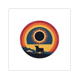 May include: A circular sticker featuring a silhouette of a bull standing on a dark landscape against a backdrop of a solar eclipse. The design includes concentric rings in shades of red, orange, and yellow, with a small white village visible.