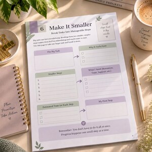 May include: A printed planner page titled Make It Smaller with sections for breaking down tasks into manageable steps. The page features light purple and green accents, checkboxes, and text prompts for planning, prioritising, and taking action.