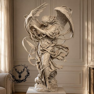 May include: A beige stone-colored sculpture of a winged figure with flowing robes and outstretched wings. The figure stands on a textured base with dynamic, swirling fabric elements surrounding the body. A black deer logo is visible on the left.
