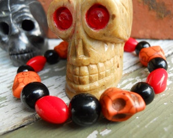 The Real Dia de Los Muertos skull stretch bracelet in orange, red and black