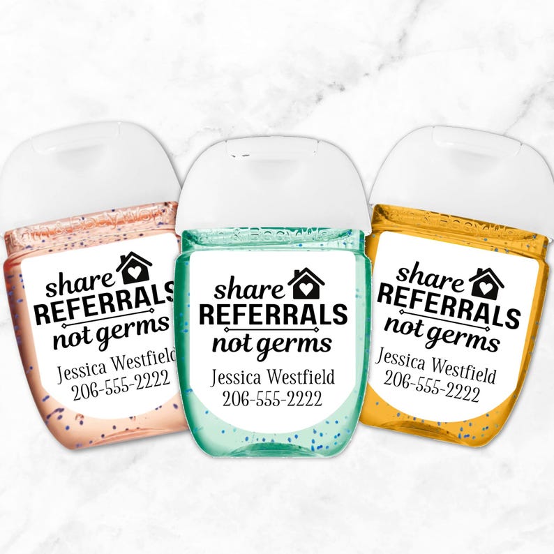 Three small bottles of hand sanitizer with white labels that say "share referrals not germs" and include a phone number and name. The bottles are peach, teal, and yellow.