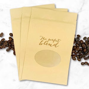 May include: Three brown paper bags with a clear window and the text "The perfect blend" printed on the front.