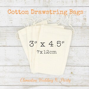 Op de afbeelding: Vijf witte katoenen trekkoordzakken met een maatlabel van 3" x 4.5", met een afmeting van 7 x 12 cm. De zakken zijn gestapeld op een houten oppervlak. De tekst "Clementine Wedding & Party" is zichtbaar onderaan de afbeelding.