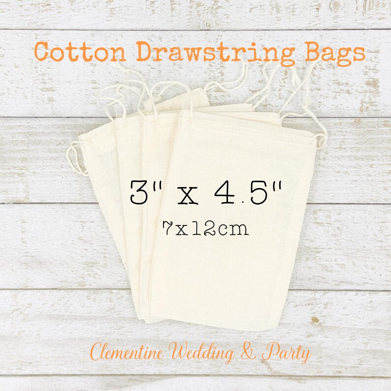 Op de afbeelding: Vijf witte katoenen trekkoordzakken met een maatlabel van 3" x 4.5", met een afmeting van 7 x 12 cm. De zakken zijn gestapeld op een houten oppervlak. De tekst "Clementine Wedding & Party" is zichtbaar onderaan de afbeelding.