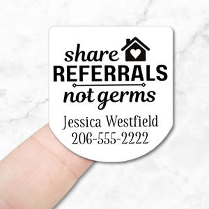 White round sticker with black text that reads "share referrals not germs". A house with a heart inside is above the text. Below the text is "Jessica Westfield" and "206-555-2222".