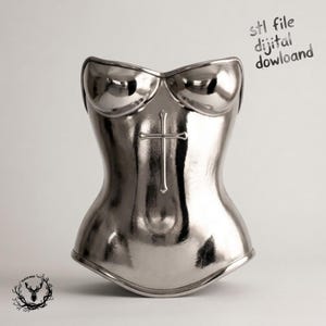 Puede incluir: Un corsé plateado metálico con acabado pulido y un emblema de cruz en relieve centrado en la parte delantera. El texto "stl file dijital dowloand" es visible en la esquina superior derecha, y un pequeño logotipo de ciervo está abajo a la izquierda.