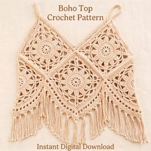 Puede incluir: Un top de ganchillo beige con un patrón de motivos florales repetitivos, tirantes finos y escote en V. El borde inferior está rematado con largos flecos colgantes. El texto "Boho Top Crochet Pattern" e "Instant Digital Download" es visible.