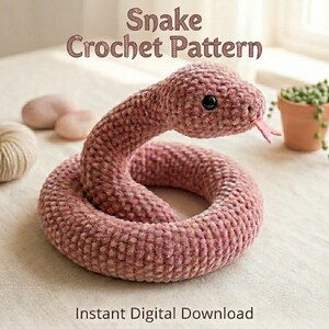 May include: A dusty rose-coloured crochet snake with a textured yarn finish, black plastic eyes, and a pink felt tongue. The text "Snake Crochet Pattern" and "Instant Digital Download" is visible above and below the coiled plush toy.