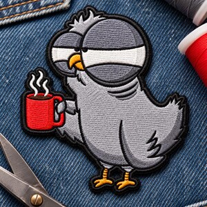 May include: An embroidered patch featuring a cartoon gray pigeon with large, tired eyes holding a bright red mug with white steam rising from it. The pigeon has a yellow beak and yellow feet, with a black stitched border outlining the entire shape.