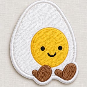 May include: An embroidered patch shaped like a fried egg with a white egg white and a bright yellow yolk. The yolk features a simple black embroidered face with two round eyes and a curved smile. Two small brown feet extend from the bottom.