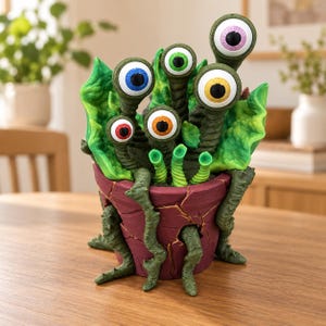 May include: A decorative sculpture featuring a cracked, dark red pot with gold-colored fissures. Emerging from the pot are several green, textured, tentacle-like stalks, each topped with a large, realistic eyeball in blue, red, yellow, or pink.