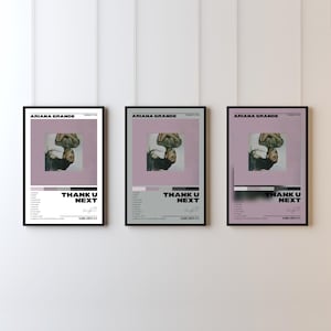Pode incluir: Três cartazes emoldurados com a capa do álbum Thank U Next de Ariana Grande. Cada cartaz exibe uma imagem central da artista, uma lista de faixas, o título do álbum, uma data de lançamento e uma assinatura. Os cartazes têm molduras pretas.