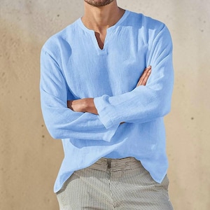Peut inclure: Une chemise &agrave; manches longues bleu clair avec une encolure en V fendue et une finition en tissu textur&eacute;. La chemise pr&eacute;sente une coupe d&eacute;contract&eacute;e avec des manches droites et un ourlet droit, offrant un look simple et &eacute;pur&eacute; au quotidien.