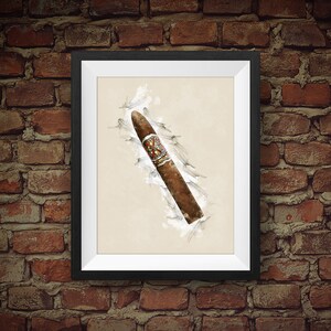 May include: A framed print of a watercolor illustration of a brown cigar with a white and red band. The cigar is depicted against a white background with a light gray watercolor wash.