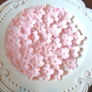 May include: A collection of pink sugar flower decorations, perfect for adding a touch of elegance to cakes and cupcakes.