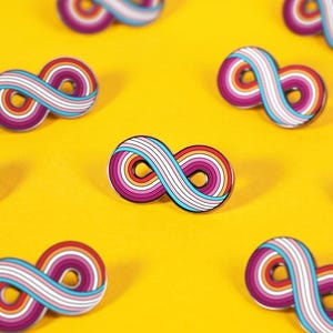Peut inclure: Plusieurs broches en émail en forme de symbole de l'infini, chacune présentant un motif rayé de couleurs rose foncé, rose clair, blanc, orange et bleu clair, disposées en un motif répétitif sur l'ensemble de l'image.