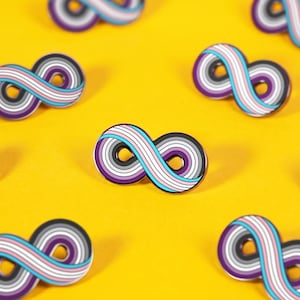 May include: Multiple infinity symbol enamel pins arranged in a pattern. Each pin features a layered design with stripes of purple, white, grey, and light blue, enclosed by a thin black outline, creating a continuous loop shape on a yellow surface.