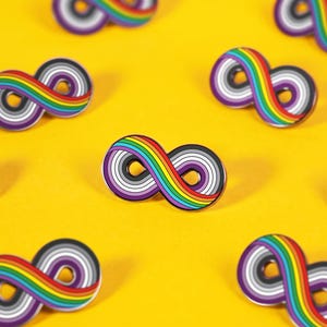 May include: Multiple enamel pins shaped like infinity symbols arranged in a pattern. Each pin features a rainbow-colored stripe along one side, transitioning into concentric rings of purple, white, and gray colors within the infinity loop design.