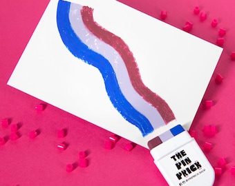 May include: A white rectangular card featuring a wavy, three-colored paint stroke in dark red, light purple, and blue. Attached to the bottom is a white plastic applicator with the text THE PIN PRICK and social media icons printed in black.