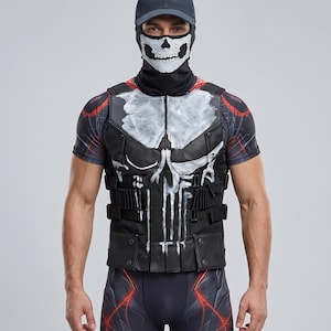 Può includere: Un gilet tattico nero con una grafica a teschio bianco sul davanti, indossato sopra una maglietta a maniche corte con motivi rossi e neri. L'outfit include un berretto da baseball nero abbinato e una mascherina nera con stampa a teschio.