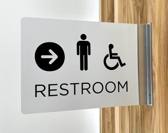 Placa de banheiro projetada com seta circular