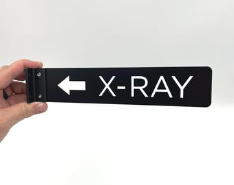 Letrero de pasillo con diseño de rayos X, 2" x 9", para consultorios médicos y hospitales. Impresión blanca sobre panel compuesto de aluminio negro con soporte, herrajes y broca.