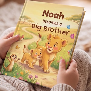 Könnte beinhalten: Ein Kinderbuch mit festem Einband und dem Titel Noah becomes a Big Brother, das eine farbenfrohe Illustration von zwei Löwenjungen und einem Erdmännchen auf einem Feldweg zeigt, umgeben von grünem Gras, Blumen, Schmetterlingen und Vögeln.