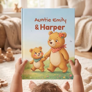 May include: A hardcover children's book with a light blue cover featuring the text "Auntie Emily & Harper" above an illustration of two brown bears walking in a field of flowers. The larger bear wears a red polka-dot bandana and a flower.