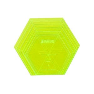 May include: A set of six clear yellow hexagon-shaped quilting rulers. The rulers are layered on top of each other and have lines and markings for quilting. The largest ruler has the text "Matilda's Own" and "Designed for Quilters" printed on it. The text "Cut Size" and "Don't Include Seam Allowance" are also printed on the ruler.
