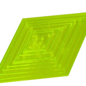 May include: A neon green, diamond-shaped quilting template. The template features a series of nested diamond shapes, each slightly smaller than the last, creating a layered effect. Small holes are visible within the inner diamonds.