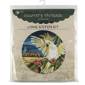 Puede incluir: Un kit de punto largo con un cacatúa blanco con cresta y alas amarillas, posado en una rama con flores rosas. El fondo incluye un cielo azul, rocas marrones y follaje verde. El kit incluye lienzo de 14 puntos, aguja de tapicería, lana de tapicería 100%, instrucciones completas de costura y un gráfico. El kit tiene un diámetro de 30 cm.