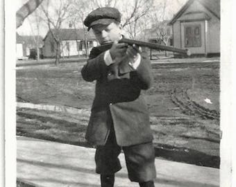 Old Photo Boy holding up Rifle on Sidewalk wearing Jacket Knickers Hat 1920s Photograph Snapshot vintage