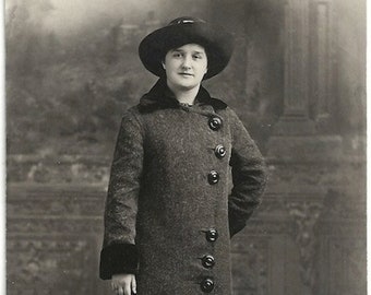 Stara pocztówka fotograficzna Kobieta w kapeluszu i płaszczu, lata 10. XX wieku, zdjęcie z epoki, duże guziki Azo Rppc
