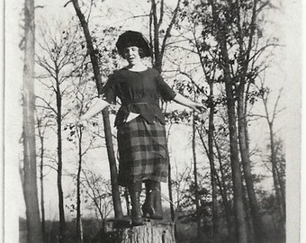 Old Photo Woman Standing on Tree Stump wearing Plaid Skirt Black Top Hat 1920s Photograph Snapshot vintage