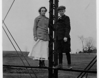 Old Photo Teen Girl and Boy Standing on Bridge Railing wearing Dress Coat Knickers Jacket Hat 1910s Photograph Snapshot vintage