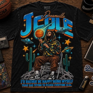 Puede incluir: Una camiseta negra con un gráfico de una persona sentada en una silla en la luna, haciendo girar un balón de baloncesto en un dedo. El diseño incluye el texto J. Cole, Dreamville y la cita I'd rather be happy being myself than sad trying to please everyone else.